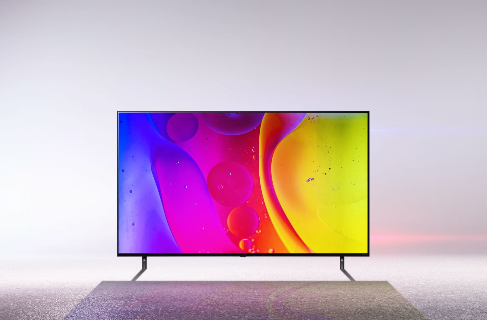 تلفزيون في غرفة بيضاء صارخة يعرض ألوانًا ساطعة ومتحركة تنويمية على الشاشة.