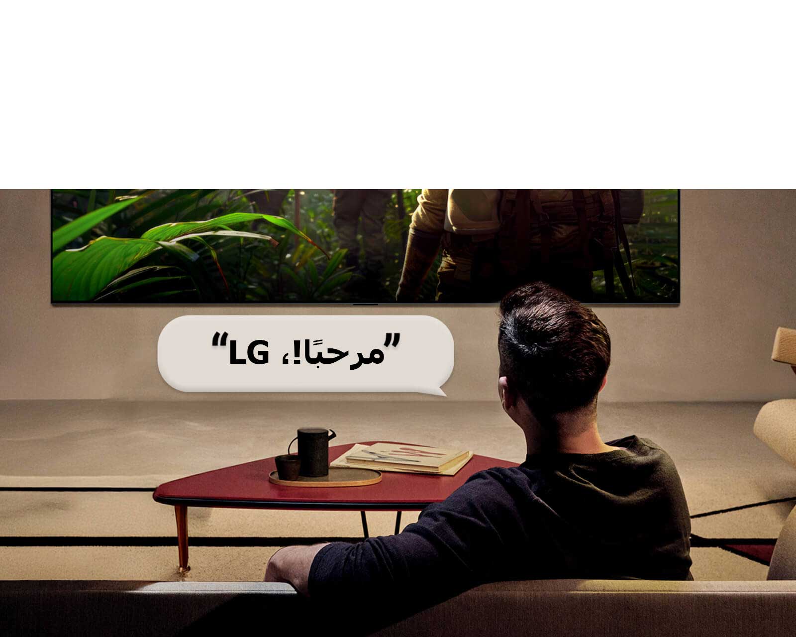 يتم تنشيط تلفزيون LG OLED AI B6 المزود بتقنية التعرف الصوتي من بُعد عبر أمر صوتي، حيث يقول شخص جالس في الغرفة "مرحبًا LG" باتجاه التلفزيون، مما يشير إلى تفاعل صوتي دون استخدام اليدين ضمن واجهة التلفزيون.