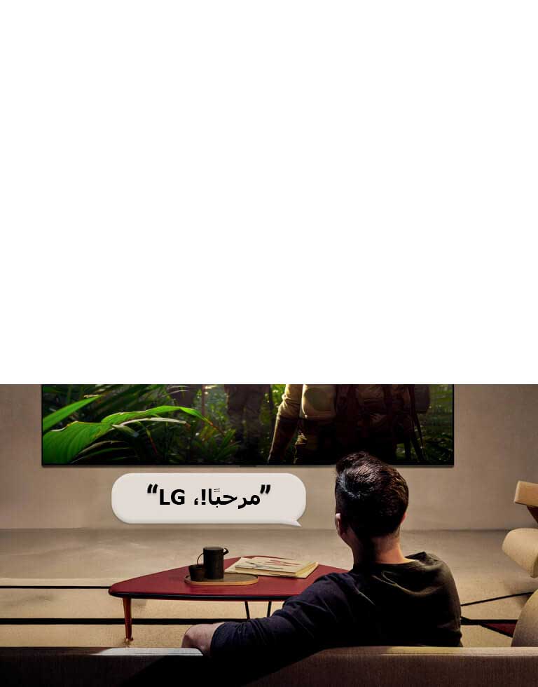 يتم تنشيط تلفزيون LG OLED AI B6 المزود بتقنية التعرف الصوتي من بُعد عبر أمر صوتي، حيث يقول شخص جالس في الغرفة "مرحبًا LG" باتجاه التلفزيون، مما يشير إلى تفاعل صوتي دون استخدام اليدين ضمن واجهة التلفزيون.