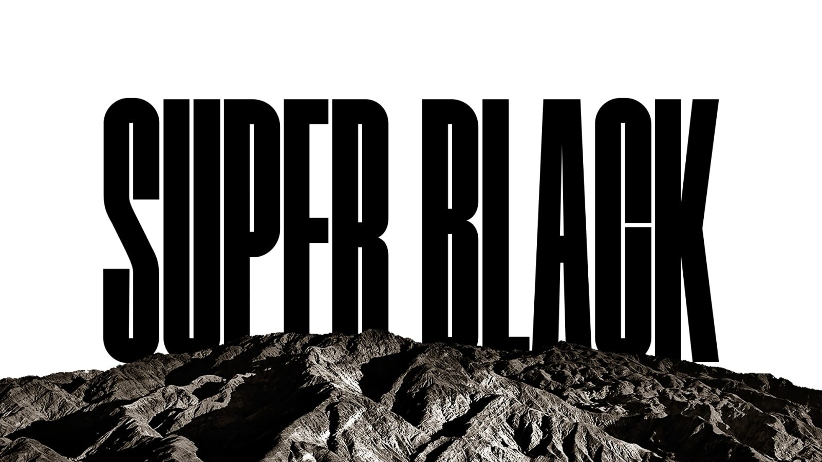 تظهر كلمتي "SUPER BLACK" (أي أسود فائق) بأحرف كبيرة باللون الأسود الغامق. يتم عرض مشهد لمنطقة جبلية سوداء عالية الوضوح ثم يرتفع المشهد ليغطي الحروف، ويكشف أيضًا عن قرية وكثبان رملية. تختفي النسخة السوداء خلف سماء سوداء.
