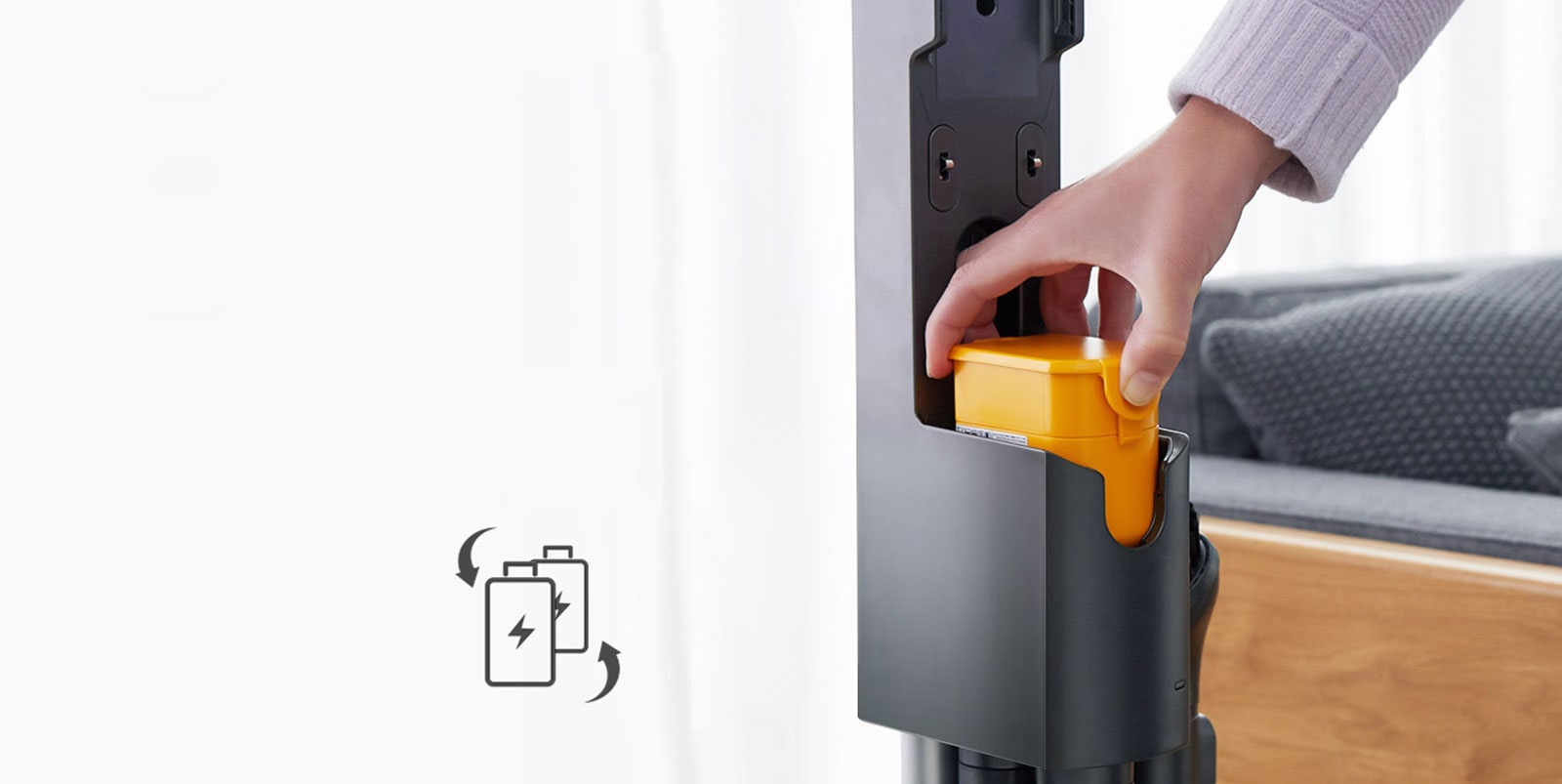 يضع يد شخص حزمة البطارية داخل المكنسة الكهربائية. على اليسار توجد أيقونة تضم بطاريتين مع علامة +60 دقيقة على الجانب وأسهم. تتحرك البطاريات للإشارة إلى إمكانية تبديلها.