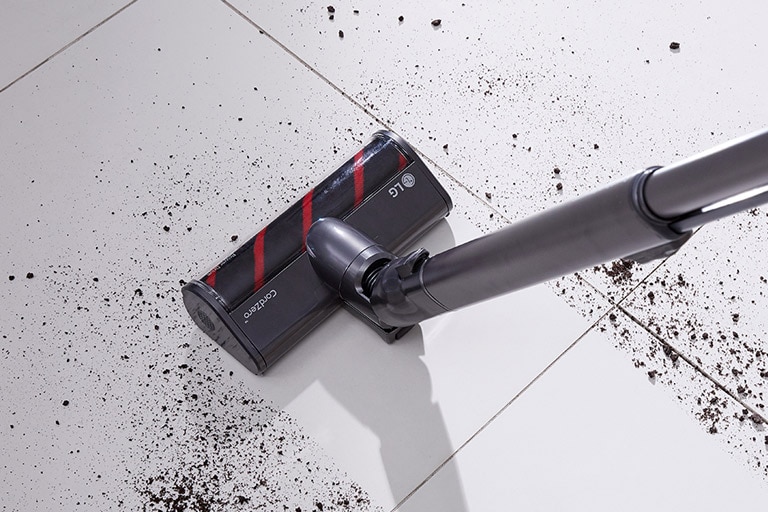 تظهر فوهة الأرضية الكهربائية وهي تنظف الأوساخ من سطح بلاط صلب.