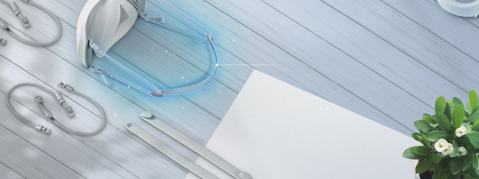 يظهر الجزء العلوي والداخلي من القناع مع شريط قماش مرن متصل في الخلف ومظلل باللون الأزرق.  توجد شرائط قماش مرنة إضافية على الطاولة حول القناع. 