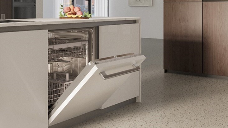 غسالة أطباق من LG بباب مفتوح ورفوف مرئية، مدمجة في طاولة مطبخ فاتحة اللون تتميز بخزائن أنيقة وتصميم بسيط.