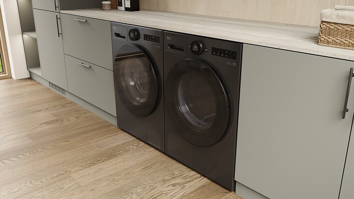 مجموعة غسالة ومجفف من LG باللون الأسود، مركبة أسفل سطح عمل فاتح اللون ضمن خزائن ذات ألوان محايدة على أرضية خشبية بتصميم أنيق.