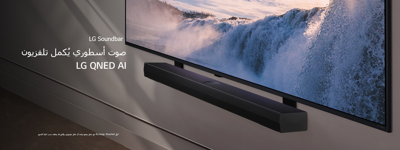 يُوضع تلفزيون LG TV ومكبر الصوت Soundbar في منظور مائل مثبت على الحائط. على التلفزيون، تٌعرض لقطة مقرّبة لشلال شاسع وضوء الشمس الناعم يتدفق على الحائط والتلفزيون ومكبر الصوت soundbar. وينص إخلاء المسؤولية على ما يلي: "يأتي Synergy Bracket مع حامل بعمود واحد أو حامل بعمودين، والذي قد يختلف حسب البلد/المنتج."