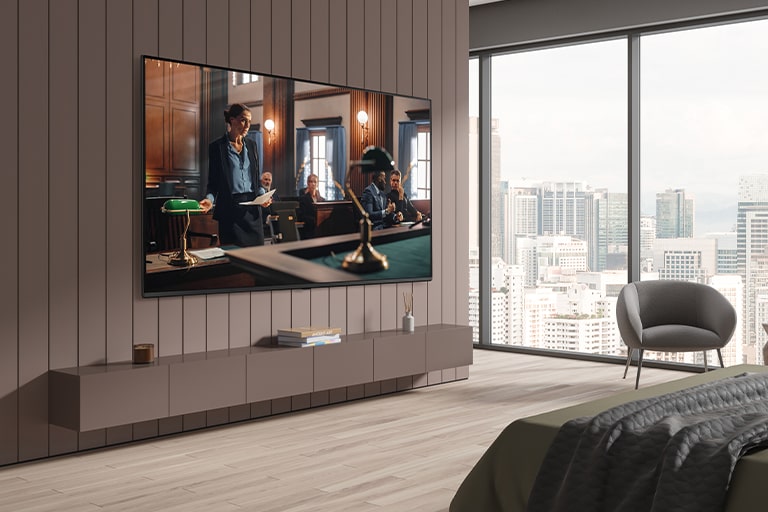 تلفزيون على حائط غرفة الفندق، وشاشة التلفزيون ساطعة وواضحة.