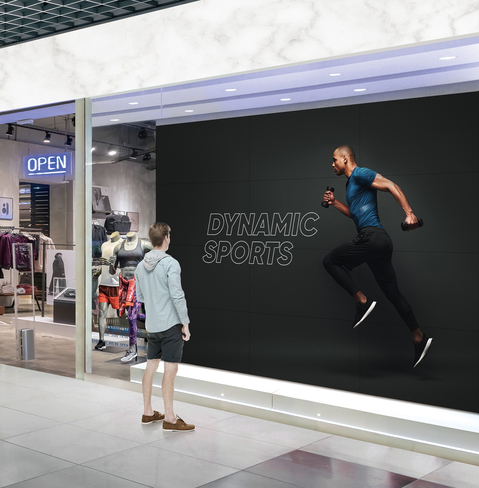 رجل ينظر إلى شاشة كبيرة متصلة بنافذة متجر رياضي.