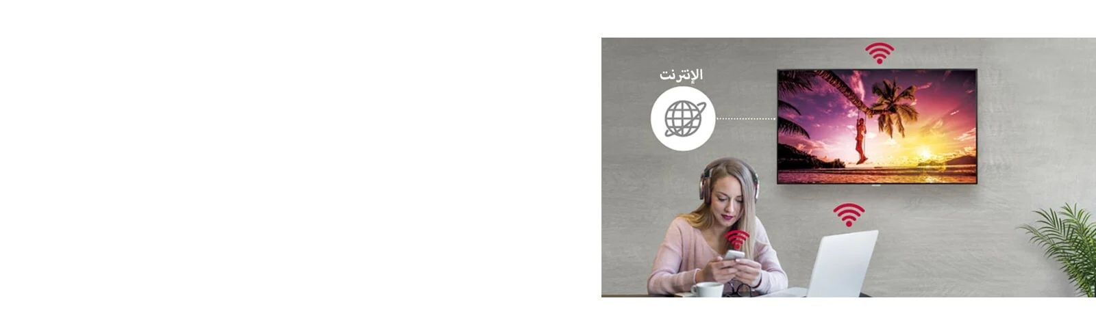 سلسلة UM3DG-H على الحائط وامرأة تستخدم جهاز كمبيوتر شخصيًا وهاتفًا محمولاً. وتوضح هذه الصورة أنه يمكن توصيل اللافتة لاسلكيًا بجهاز الكمبيوتر والهاتف المحمول الذي تحمله المرأة.