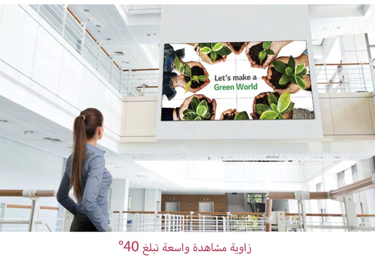 امرأة تنظر إلى شاشة مثبتة في الطابق العلوي.