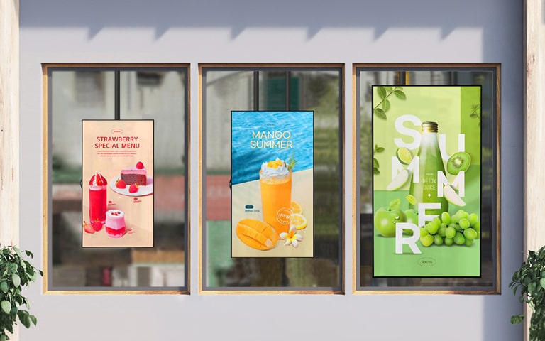 ثلاثة أحجام مختلفة من XS4P مثبتة على النافذة داخل المقهى. يظهر المحتوى بوضوح وحيوية من خلال الزجاج، حتى في الأجواء الساطعة.