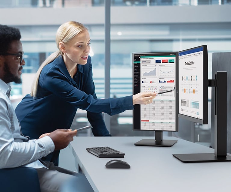موظفان يتناقشان مع زميلتهم أثناء النظر إلى الشاشة في المكتب.	