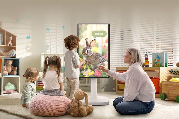 تعرض هذه الصورة امرأة وثلاثة أطفال يلعبون باستخدام شاشة LG Smart Monitor Swing.	