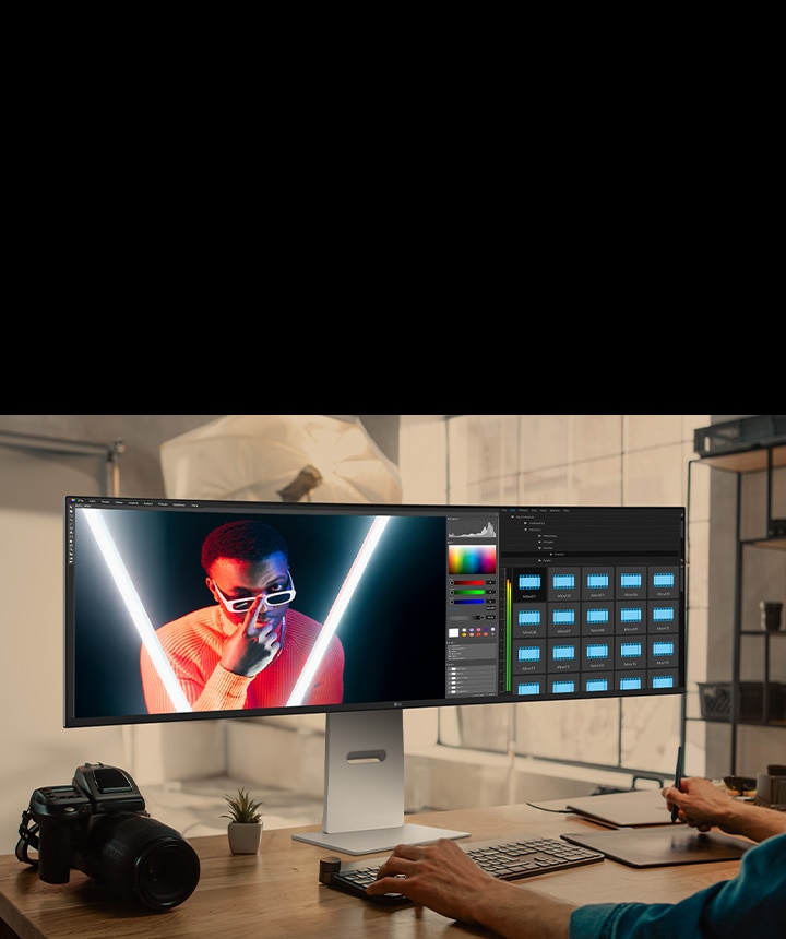 يقوم المصمم بتحرير المحتوى المرئي على شاشة LG UltraWide monitor، ويعرض تصنيف الألوان وتصميم التخطيط بوضوح عالي الدقة.	