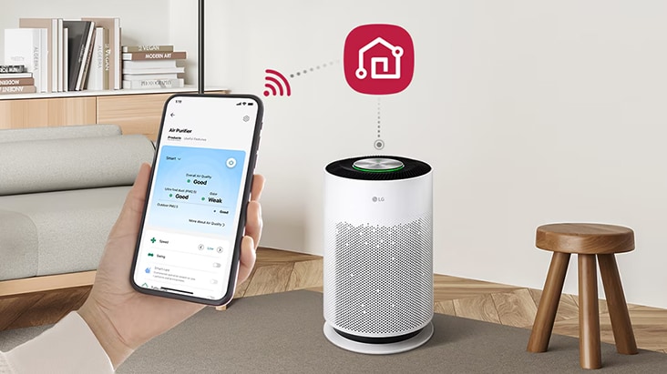 يد تمسك بهاتف ذكي مع تطبيق LG ThinQ للتحكم عن بُعد في جهاز تنقية الهواء الأسطواني عبر Wi-Fi.