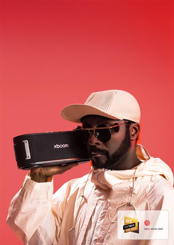 will.i.am يرتدي زيًا أبيض ونظارات شمسية ويمسك جهاز xboom Bounce بجانب وجهه مباشرةً.