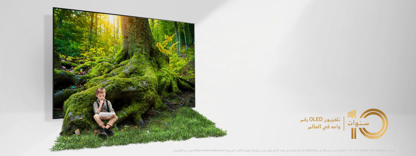 جذر شجرة عملاقة يخرج من شاشة التلفزيون ليغطي الأرضية بالعشب. طفل جالس على العشب.