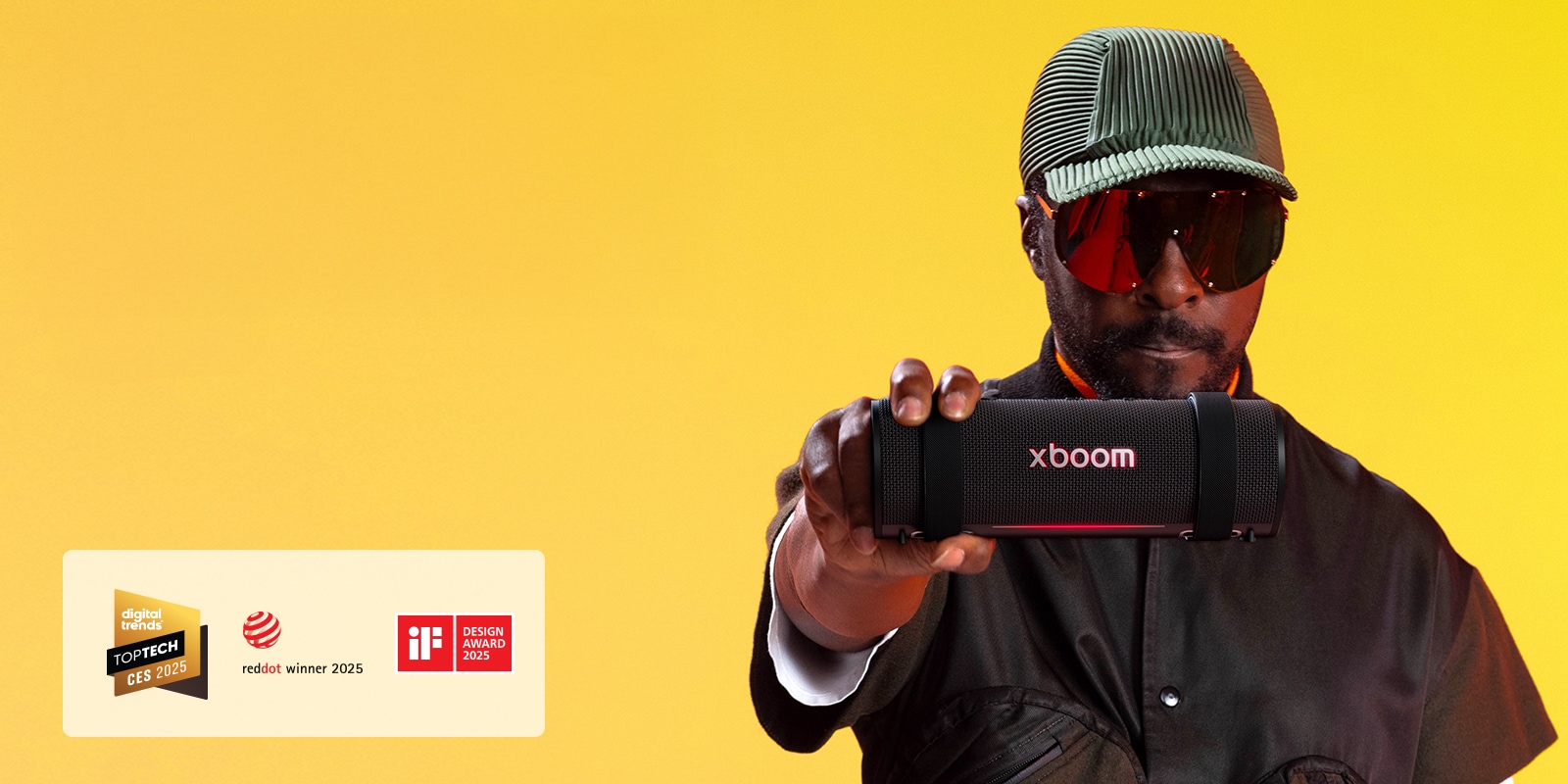 will.i.am يرتدي زيًا أسود ويمسك جهاز xboom Grab للأمام