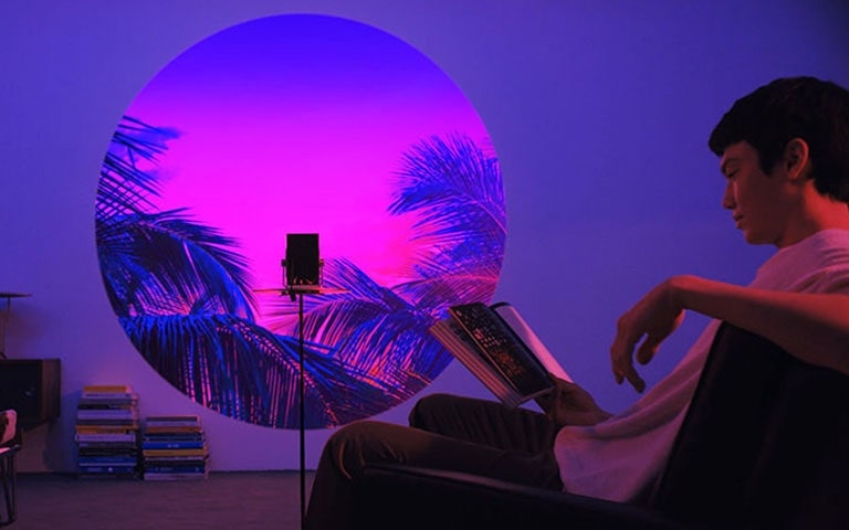 مشهد يعرض تطبيق ميزة الرسم بالضوء - قراءة كتاب في غرفة المعيشة.