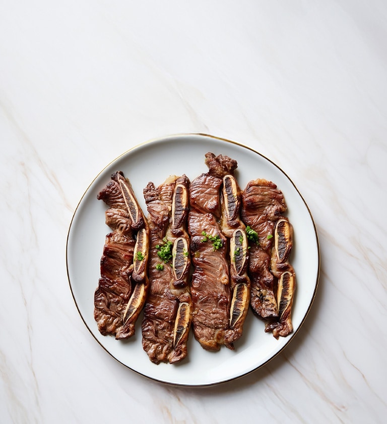 AI-generated image of a Marinated and Grilled Beef Short Ribs dish.