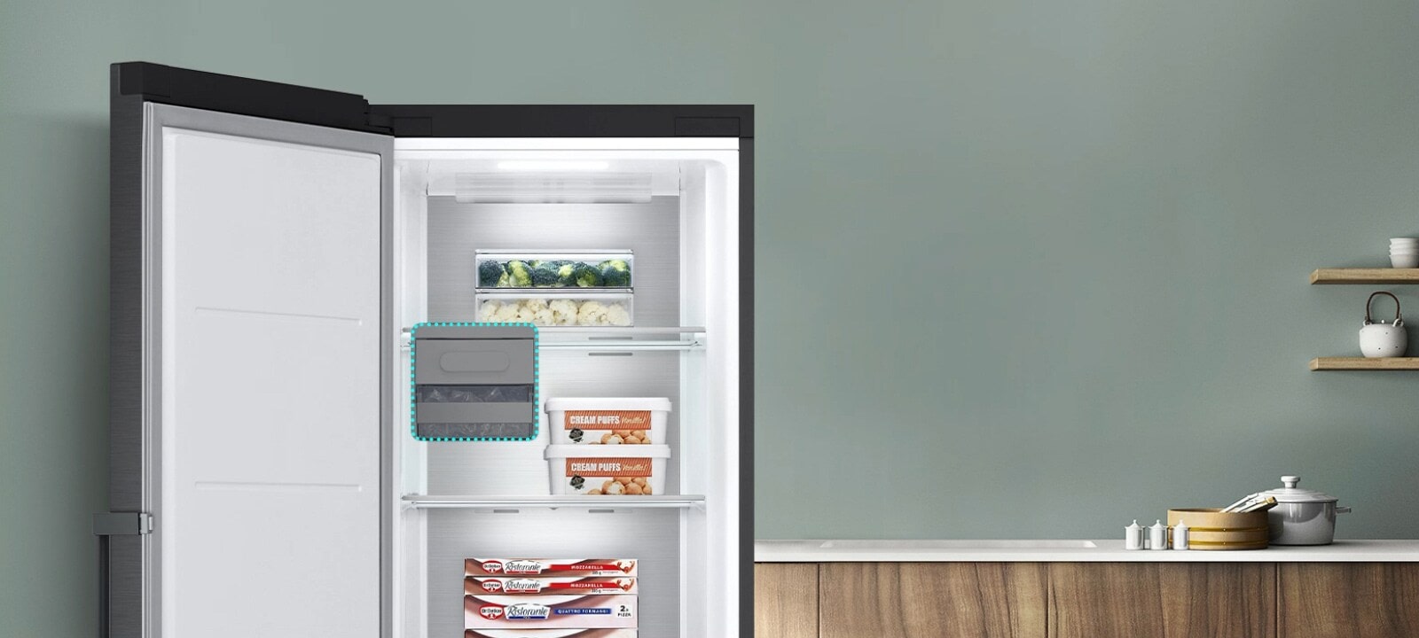 The freezer is open and items are placed on various shelves. A blue dotted line highlights where the ice maker could be but shows that it can be removed for extra storage space.