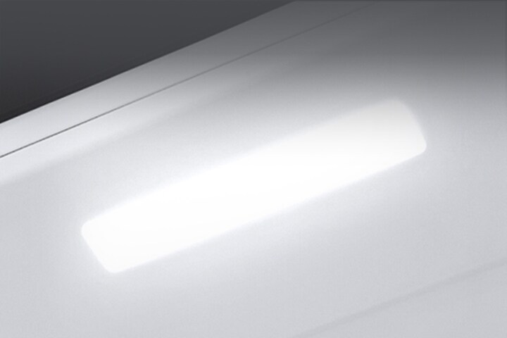The top interior of the fridge is shown with the soft LED light bright.	