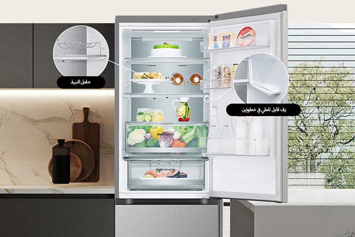 ثلاجة جديدة معبأة بالطعام مع باب مفتوح يعرض حامل النبيذ ورف قابل للطي.	