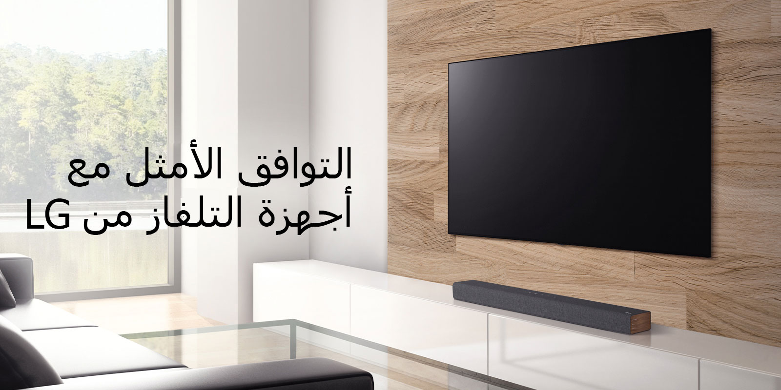 توجد سماعة في كابينة التلفاز البيضاء ويوضع التلفاز على جدار خشبي. هناك مشهد غابة خارج النافذة. نص مكتوب على الصورة - التوافق الأمثل مع أجهزة التلفاز من LG. 