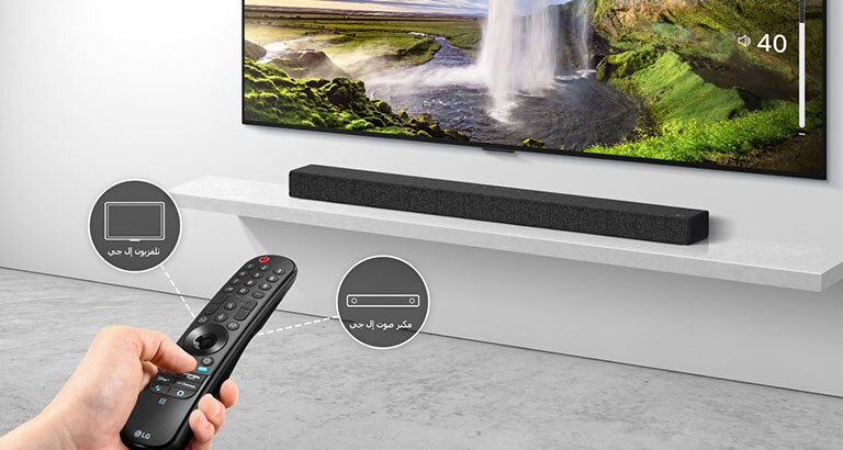 يوجد جهاز تحكم عن بعد في يد شخص ما، يتحكم في التلفزيون ومكبر الصوت في الخلف. توجد أيقونات لتلفزيون LG ومكبر صوت LG Soundbar.