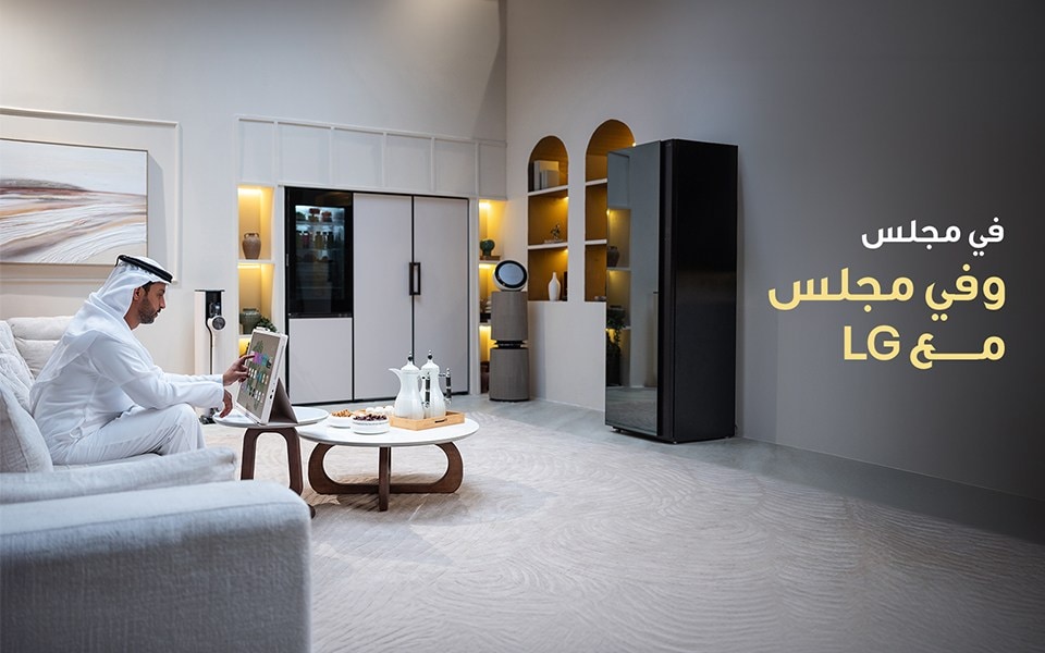 مجلس إل جي يعرض رجلاً يستخدم جهاز LG StanbyME في غرفة معيشة عصرية مزودة بأجهزة إل جي الذكية الأنيقة.