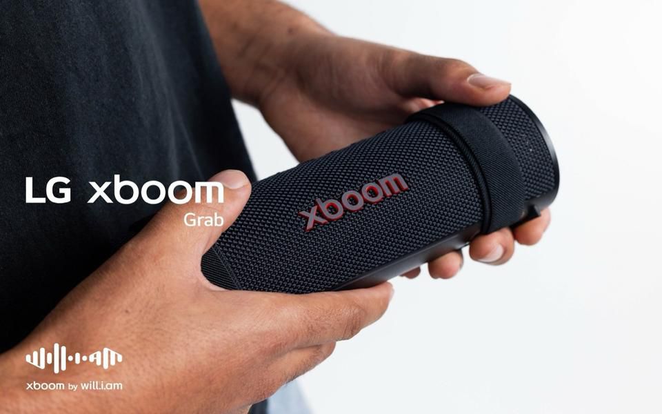 Person holding a portable LG xboom Grab Bluetooth speaker for music on the go.