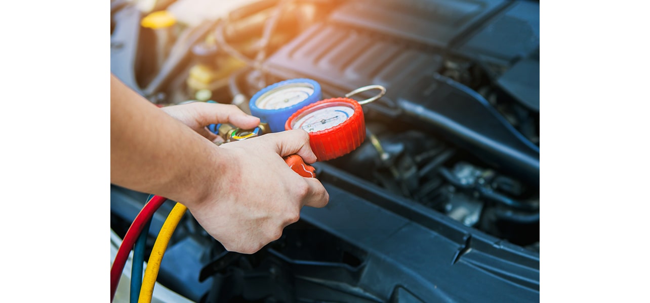 A person checking the car refrigerant pressure