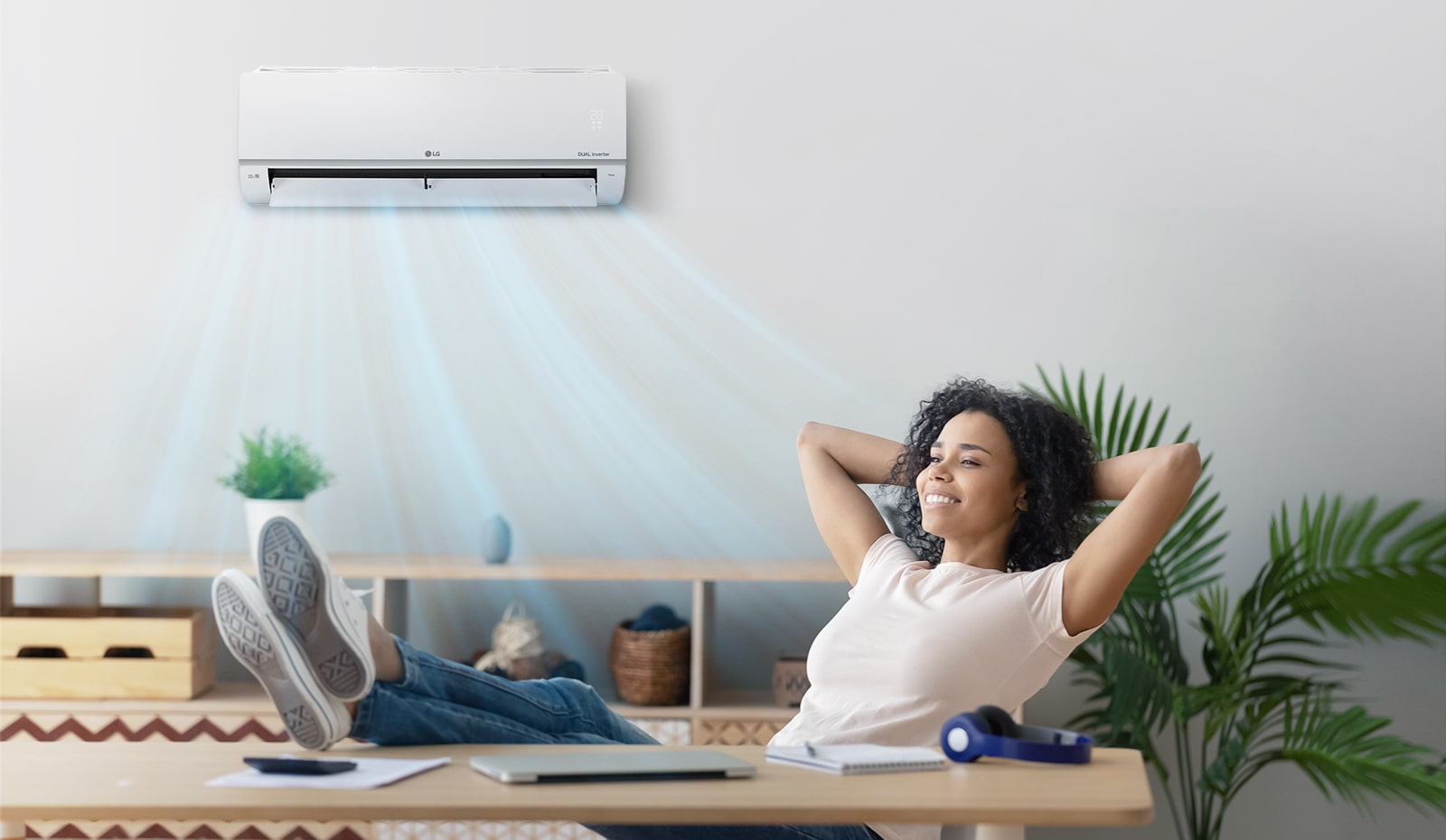 A woman who closes her eyes and relaxes under a quiet air conditioner.