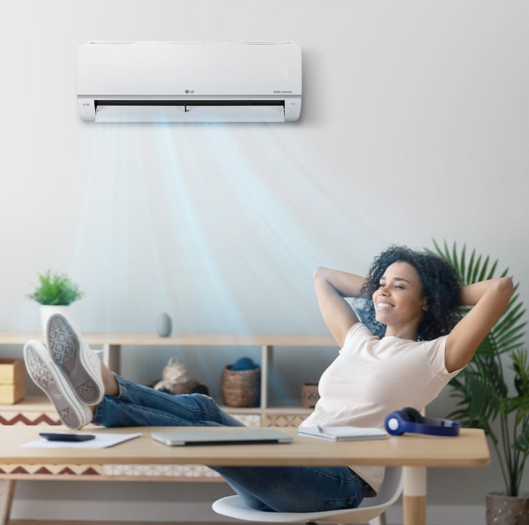 A woman who closes her eyes and relaxes under a quiet air conditioner.