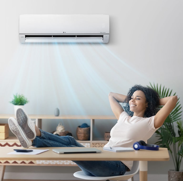 A woman who closes her eyes and relaxes under a quiet air conditioner.