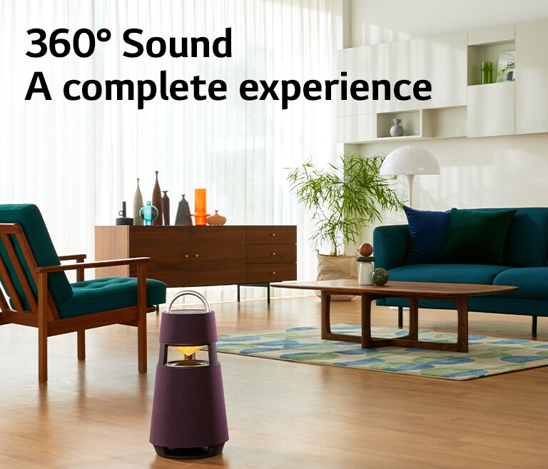 An image of a woman sitting on a sofa listening to music with an XBOOM 360 in front of her.