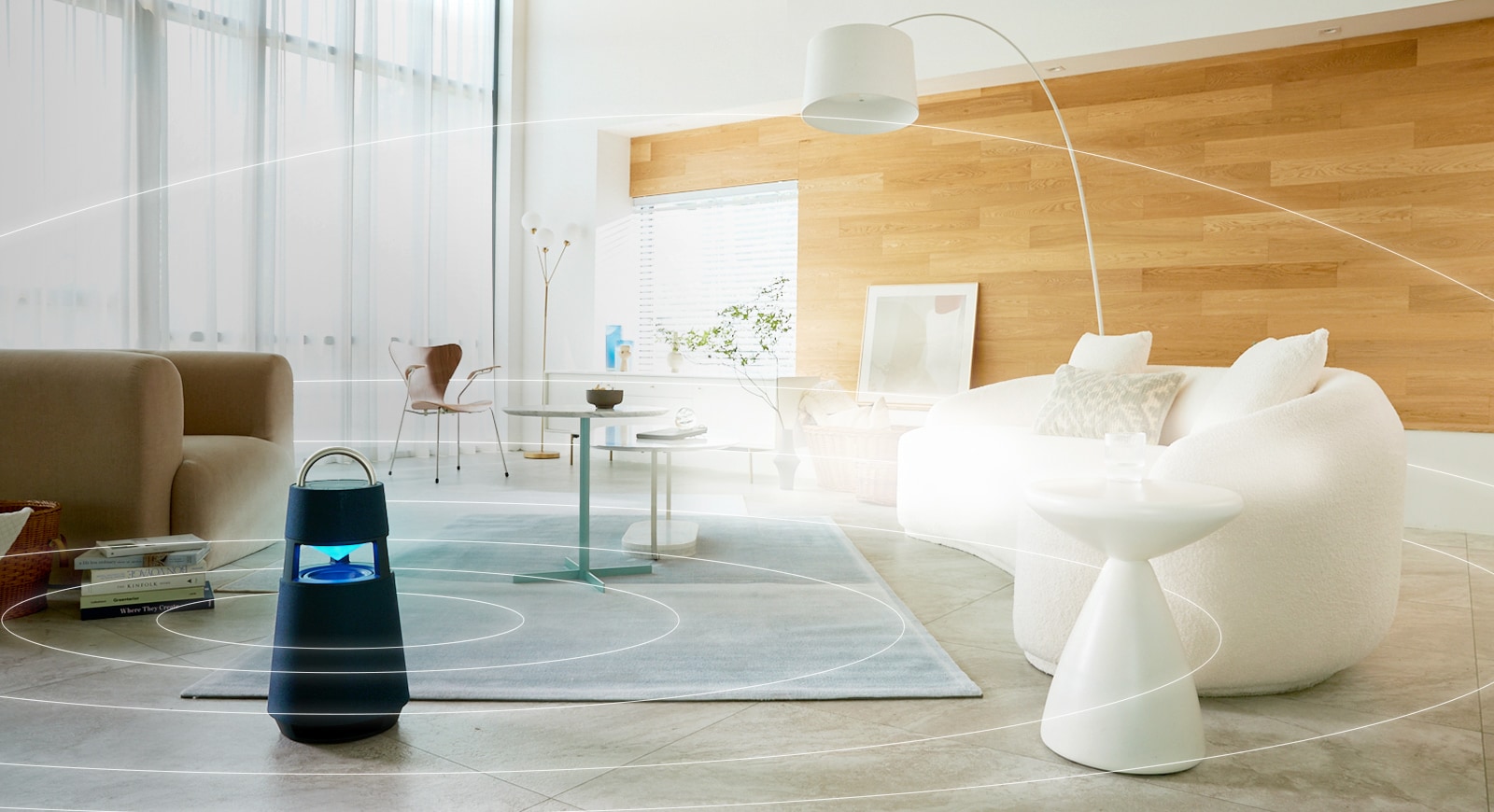 Image of sound waves spreading around XBOOM 360 lying on the floor of a minimal living room space.