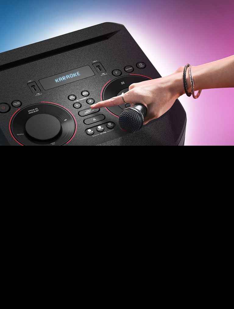 A hand holding a microphone tries to press the Voice canceller button on the top of LG XBOOM.