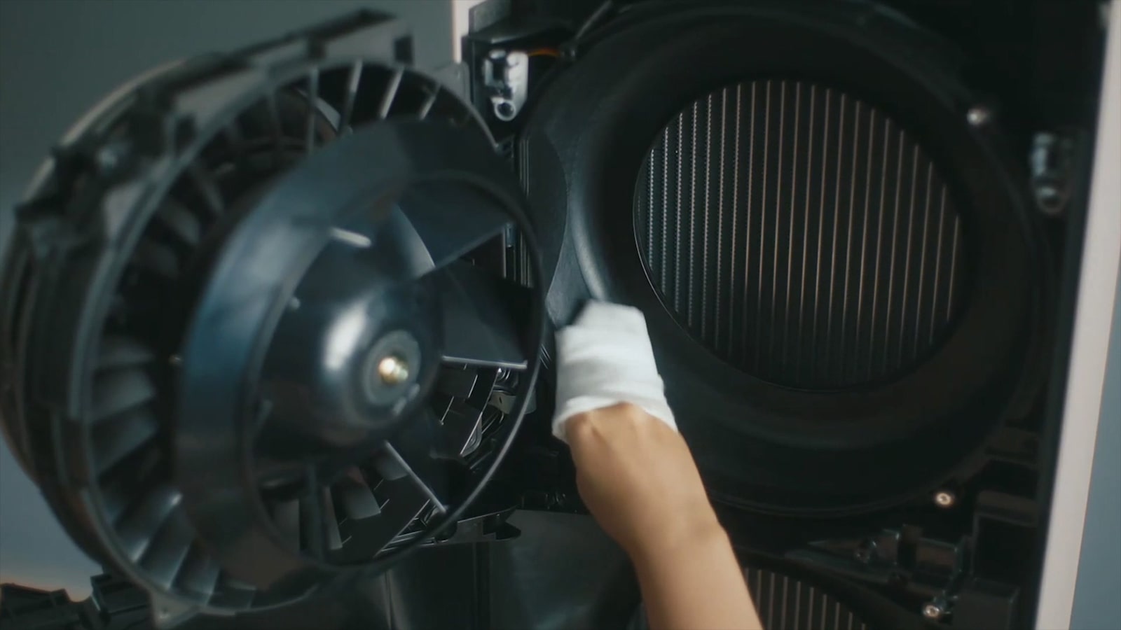 A person wipes the inner side of the air conditioner to clean