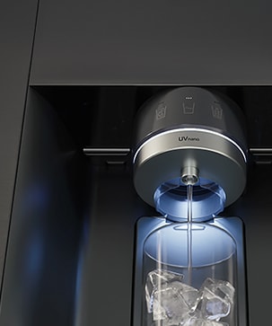 Water is flowing from a refrigerator dispenser labeled ‘UVnano,’ and the water is being poured into a cup.