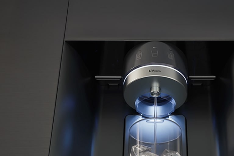 Water is flowing from a refrigerator dispenser labeled ‘UVnano,’ and the water is being poured into a cup.