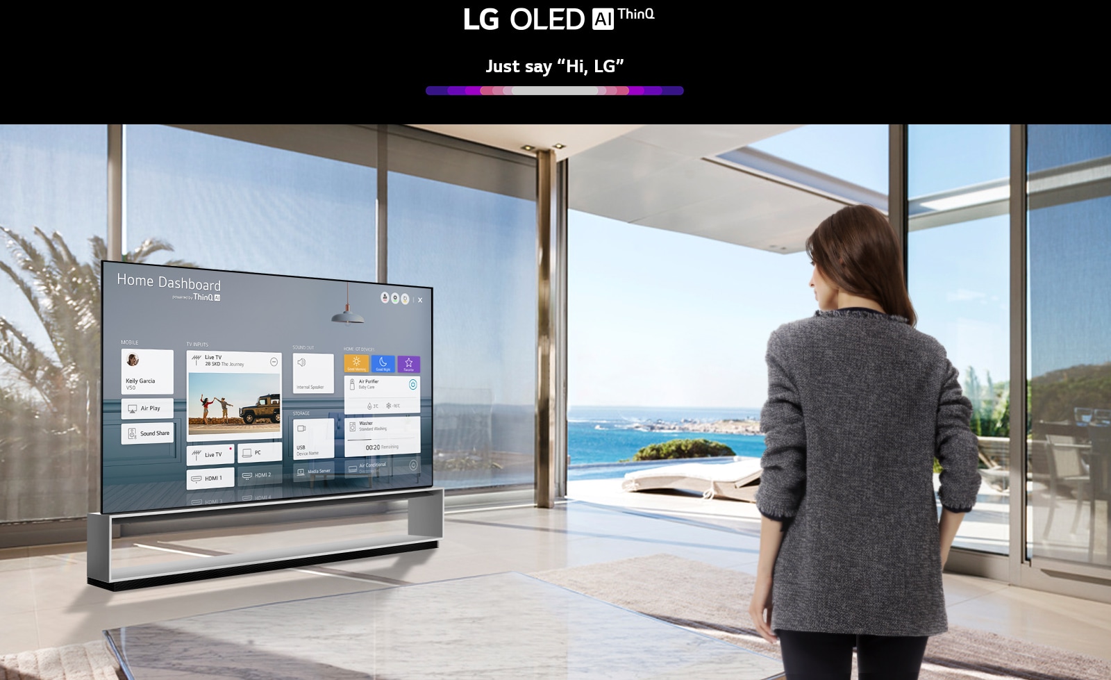 Mother and daughter sitting on a sofa in the living room with the Home Dashboard on the TV screen