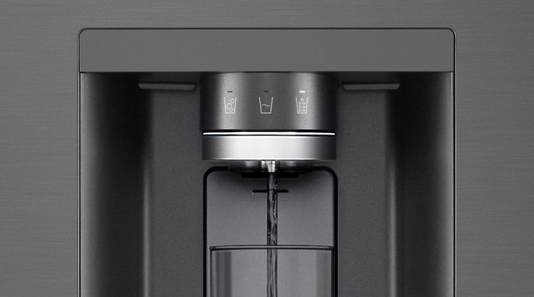 A video starts zoomed in on the water dispenser. The exterior of the refrigerator goes clear and now the interior of the door and mechanical parts of the dispenser nozzle can be seen. The video zooms in further to show the water droplets as they fall through the UVnano part of the nozzle which reduces the bacteria. The view zooms back out to see the exterior of the refrigerator again as water is being dispensed into a glass.