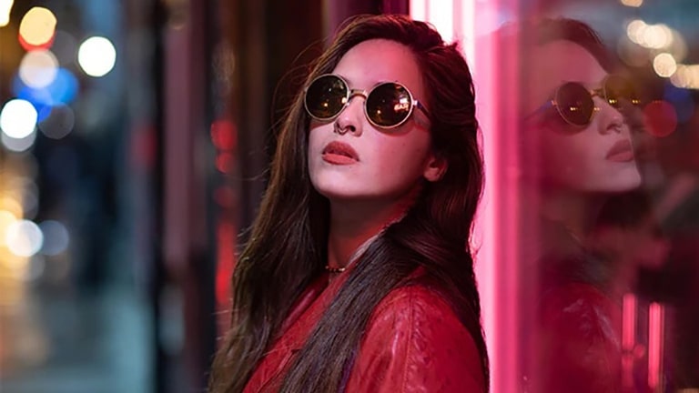 A scene of a woman wearing sunglasses is divided into two for visual comparison. On the image, there are text of SDR on the bottom left and Dolby Vision IQ logo on the bottom right.