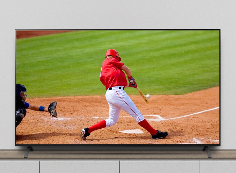 The TV is on the stand, and the screen shows a baseball match.