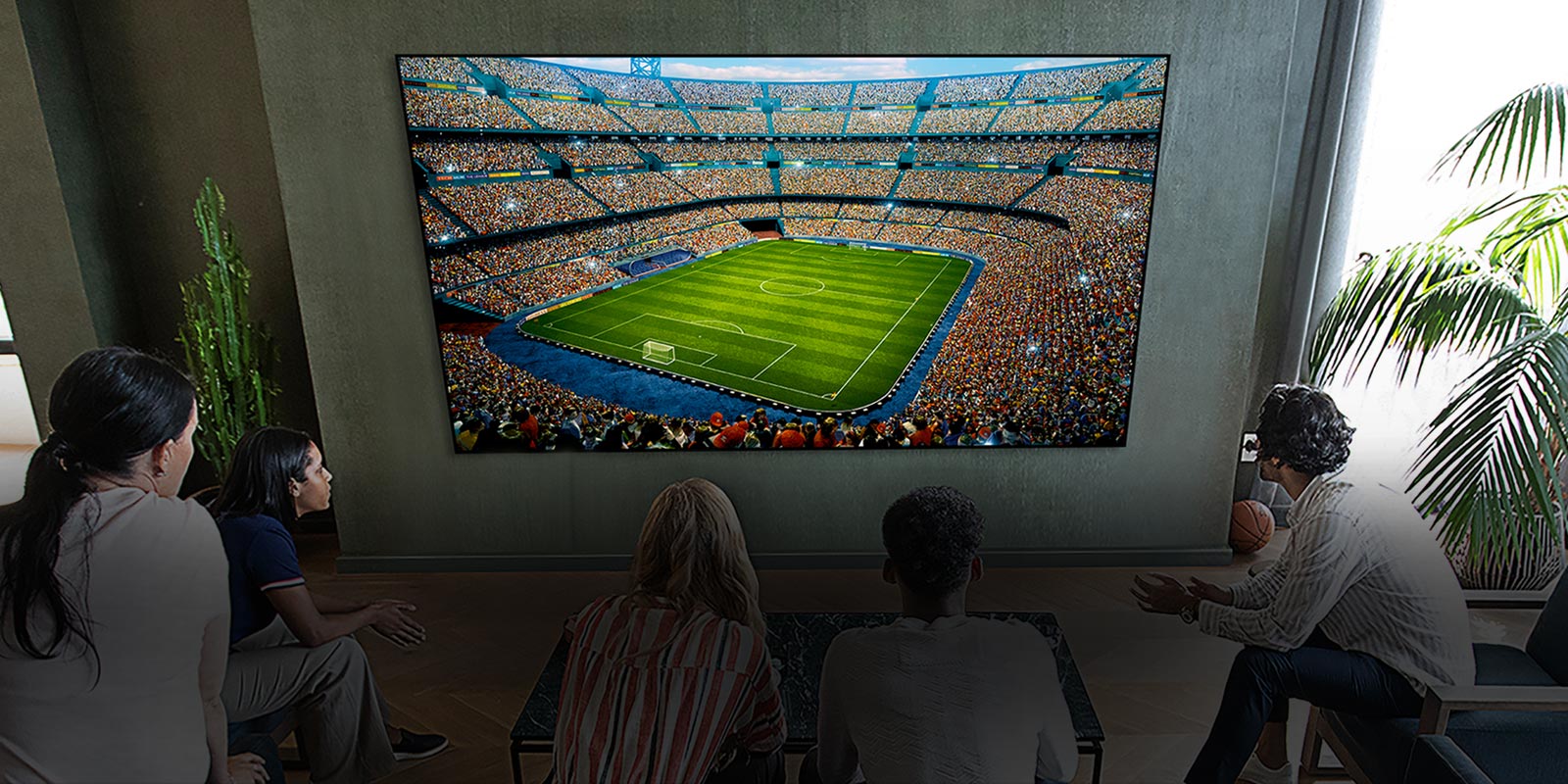 People watching a soccer game on a large TV screen in the living room