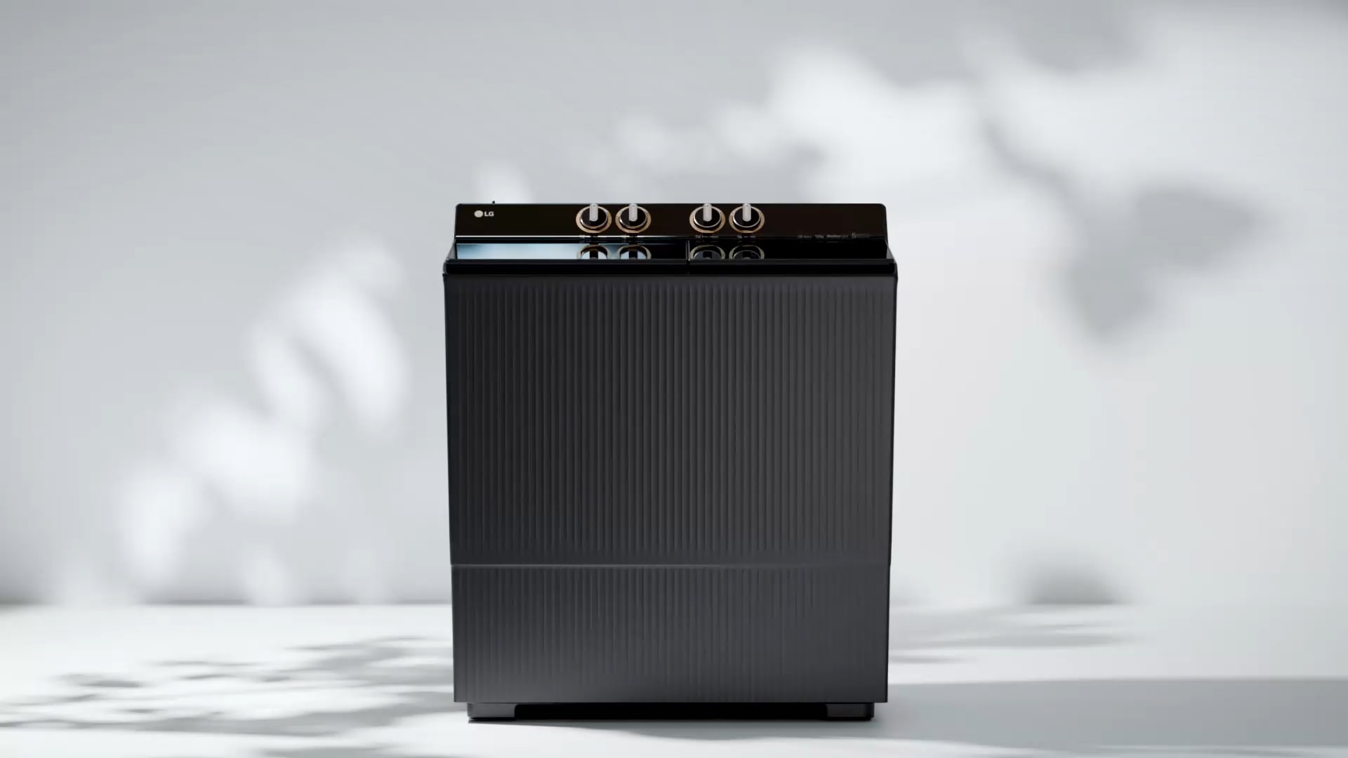 Front view of a modern black top-loading washing machine with control dials on top, displayed on a clean white background.