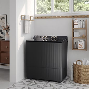 Black top-loading washing machine placed in a bright modern laundry room with shelves, baskets, and natural light