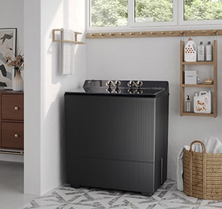 Black top-loading washing machine placed in a bright modern laundry room with shelves, baskets, and natural light