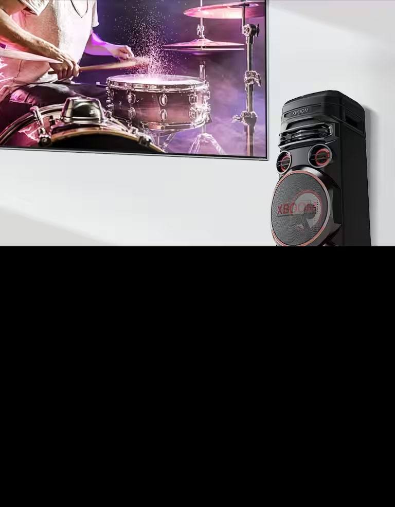 A TV is on a wall with an LG XBOOM to the right of it.